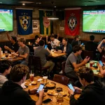 Kết quả bóng đá displayed on large screens as fans engage in betting excitement at a sports bar