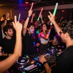 8Day electronic music event with DJ mixing tracks and vibrant crowd enjoying the rhythm